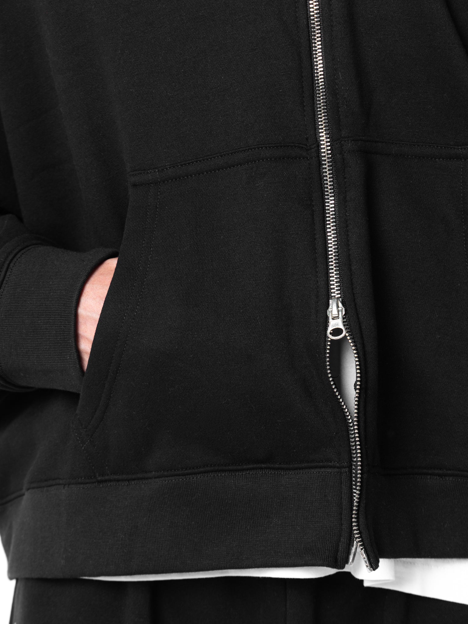 Close-up of a black zip-up hoodie with a zipper detail.
