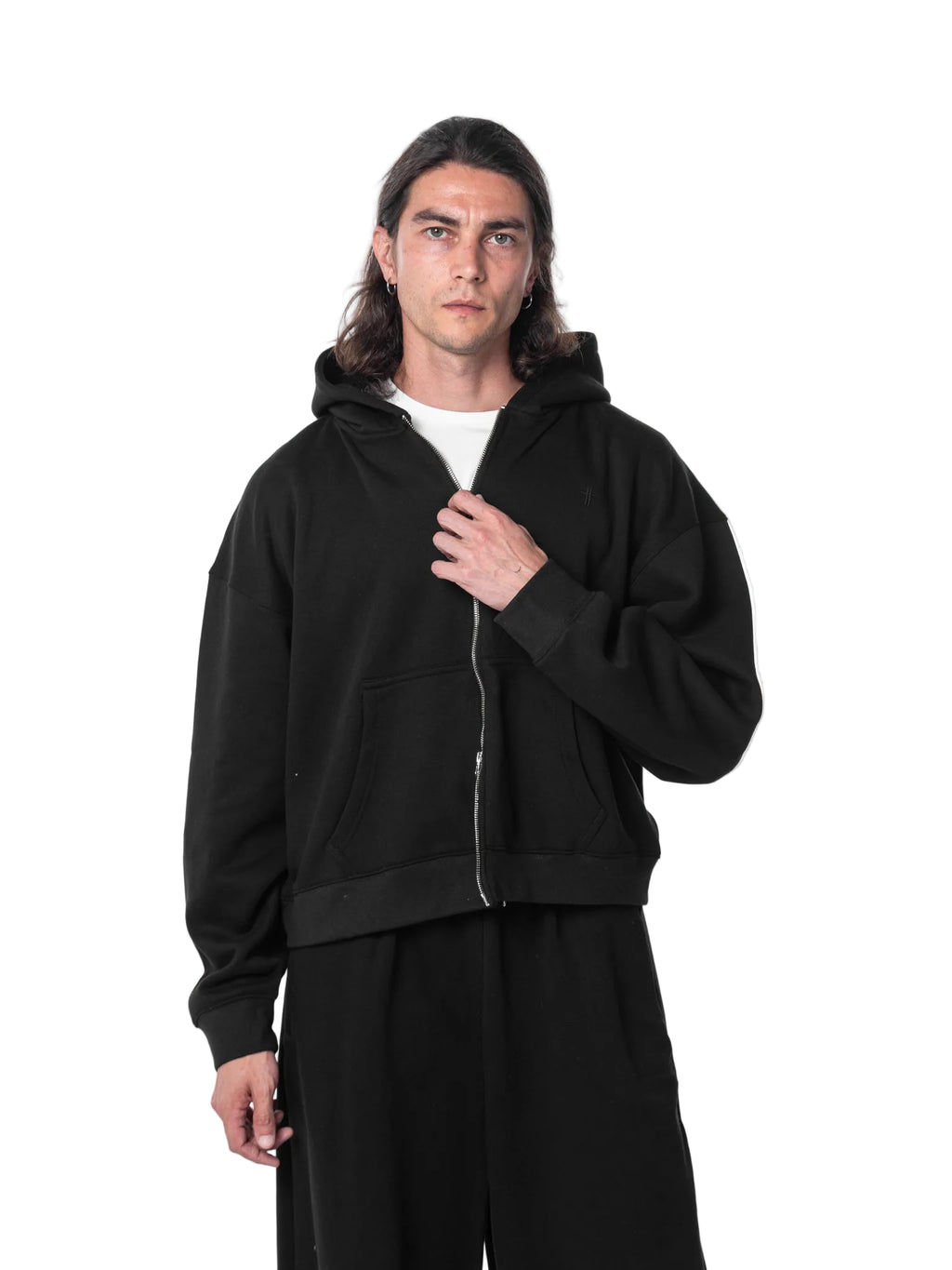 Person wearing a black hoodie and pants on a white background