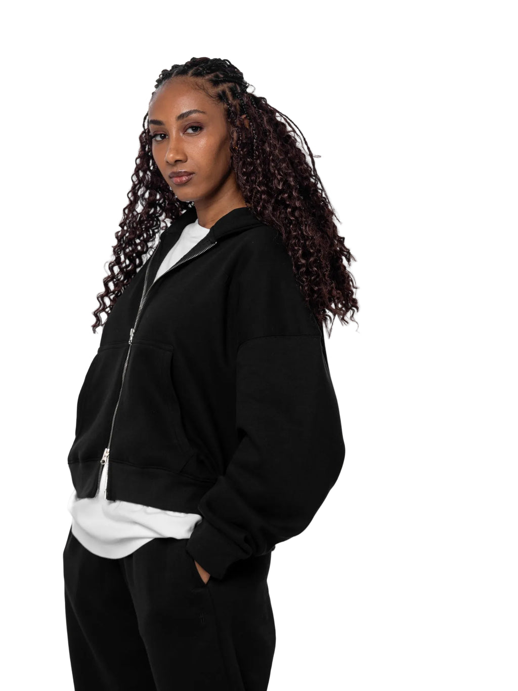 Woman wearing a black jacket over a white shirt on a white background